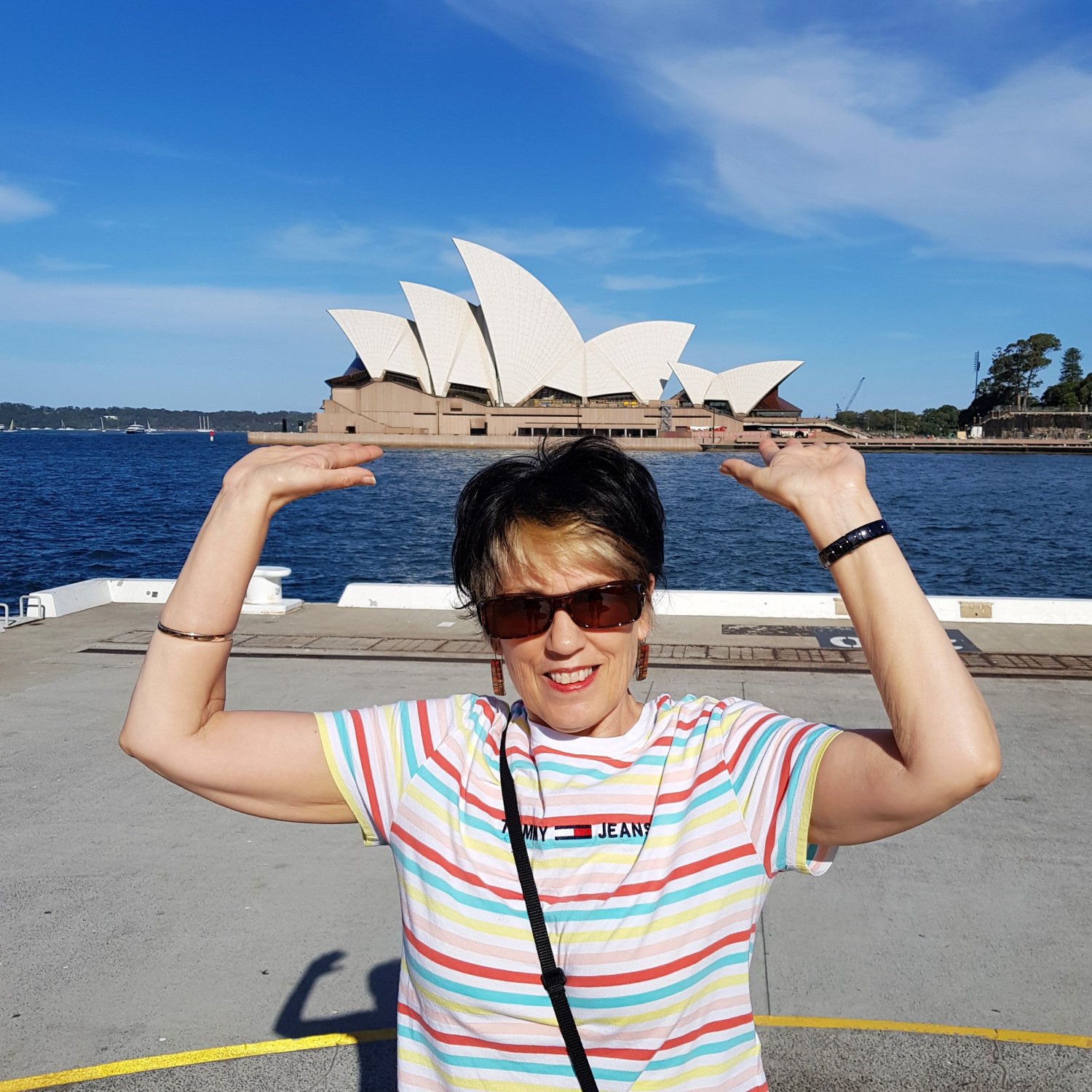 Marlene standing opposite the Sydney Opera House, appearing to lift the building out of the harbour, 2019