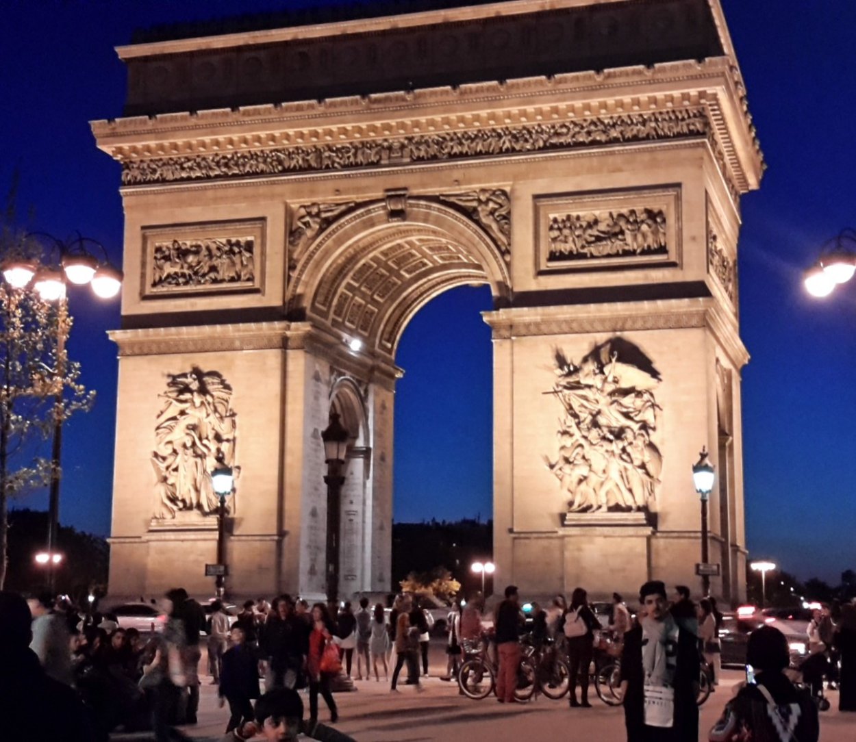 image of tourists at night at the Arc de Triomphe, Paris