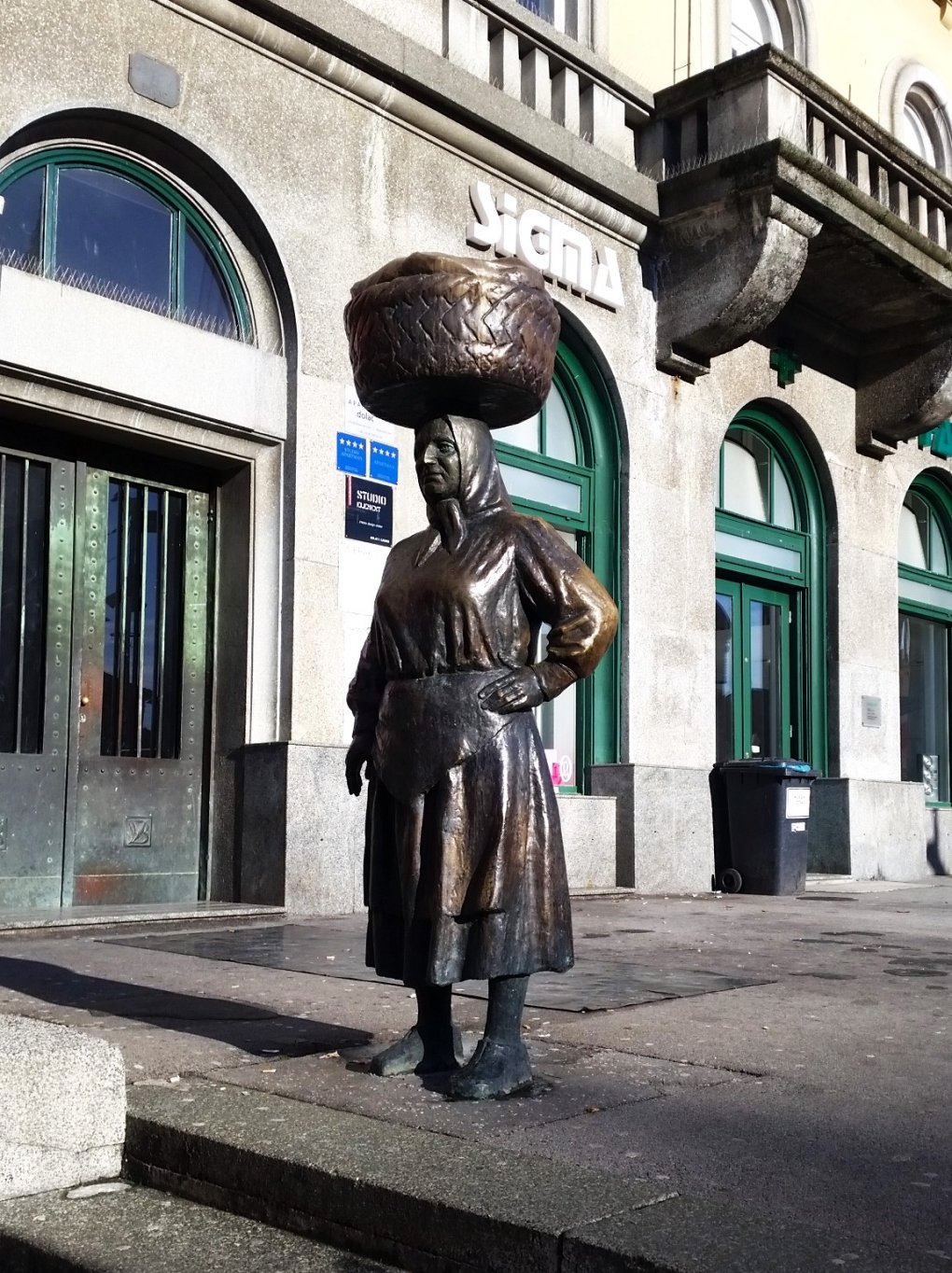 image of peasant woman balancing a basket of goods on her head, at Zagreb's Dolac Market