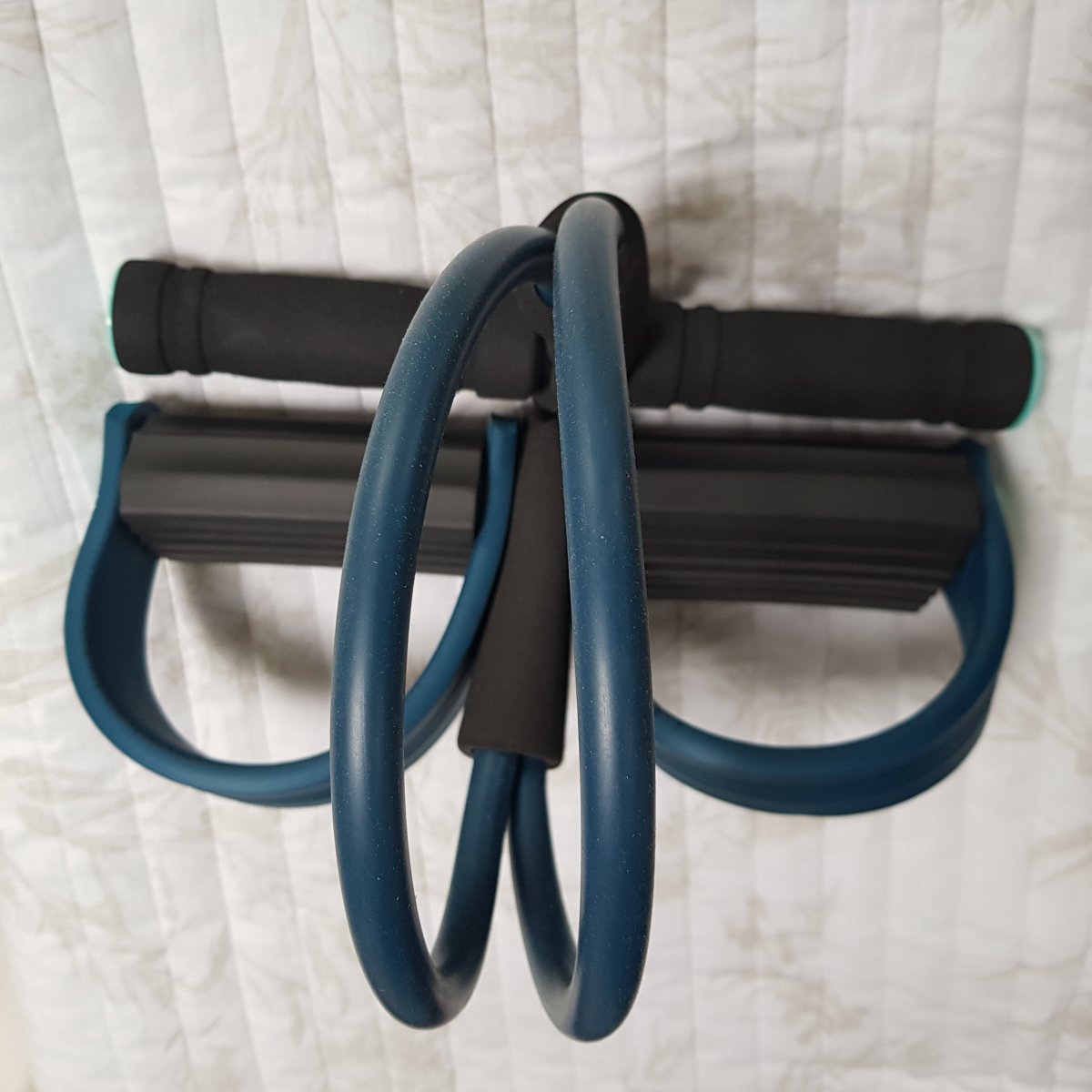 Combination of four images of resistance bands, ranging from simple large band, to more complex stirrup band