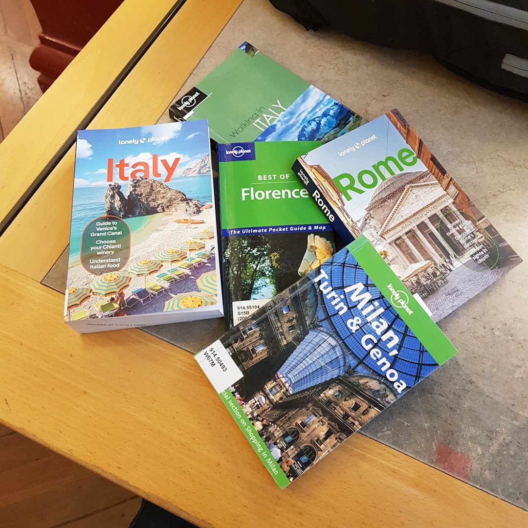 Image of various offline research resources for planning a visit to Italy