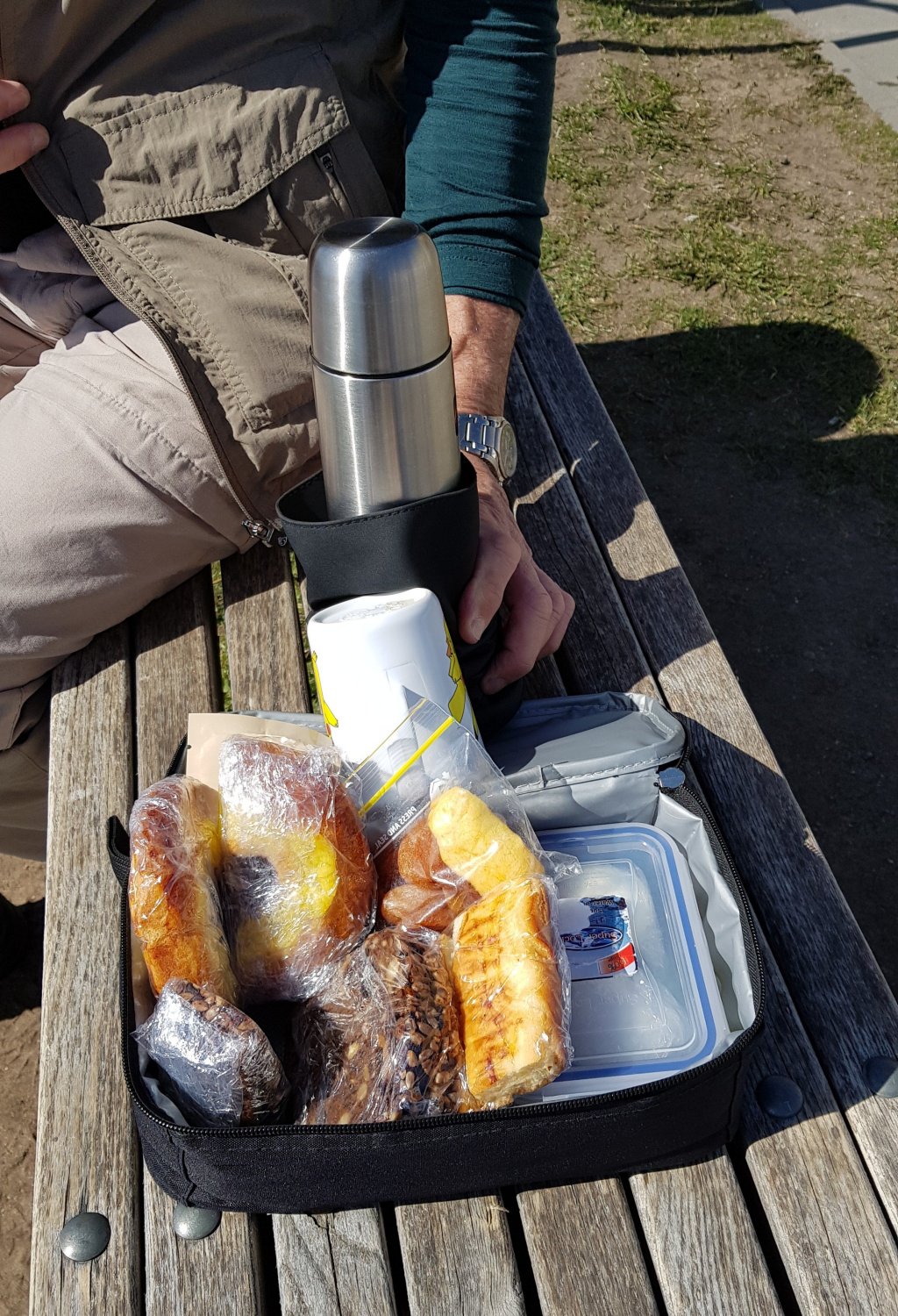 image showing contents of a lunch pack - pastries, bread, and a thermos containing hot coffee