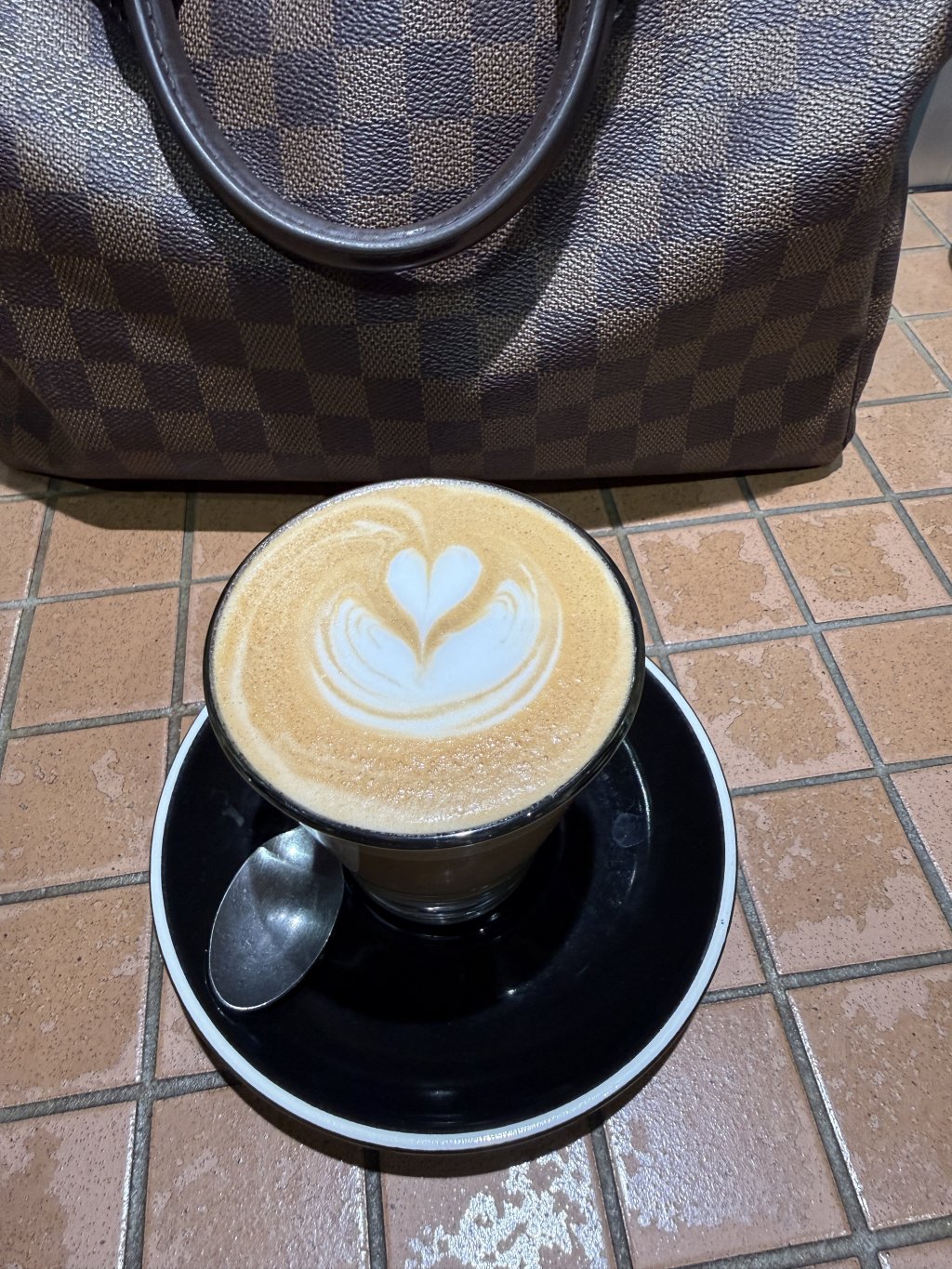 image of a coffee cup beside a Louis Vuitton bag