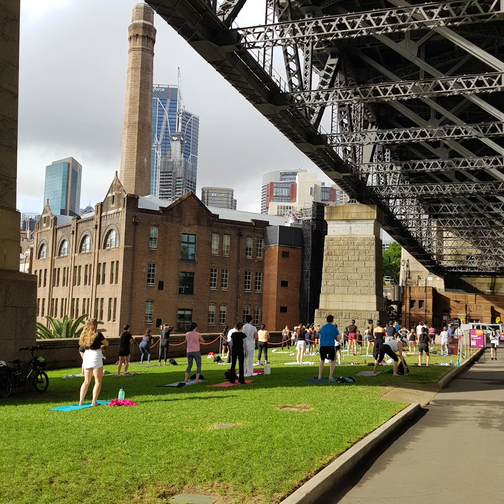 Yoga in the open space beneath the Sydney Harbour Bridge, viewed from near George Street.